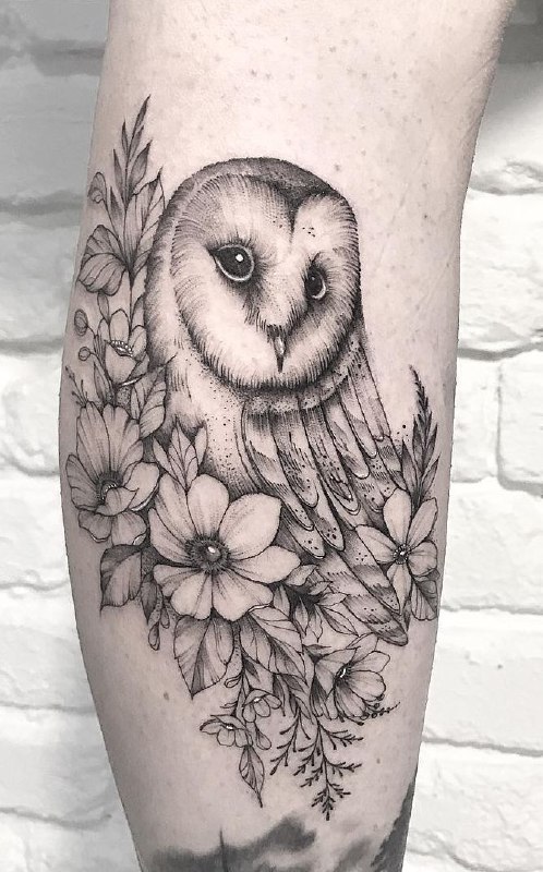 Large tattoo of an owl and flowers on the shin for men