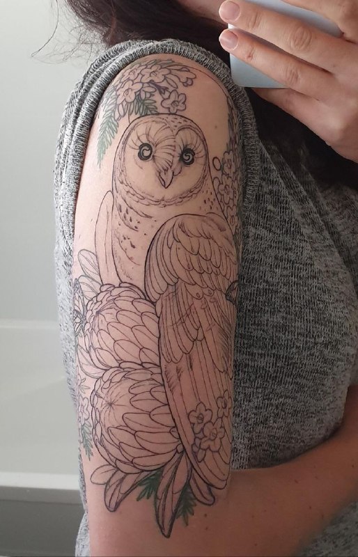 Large owl tattoo on the arm for women