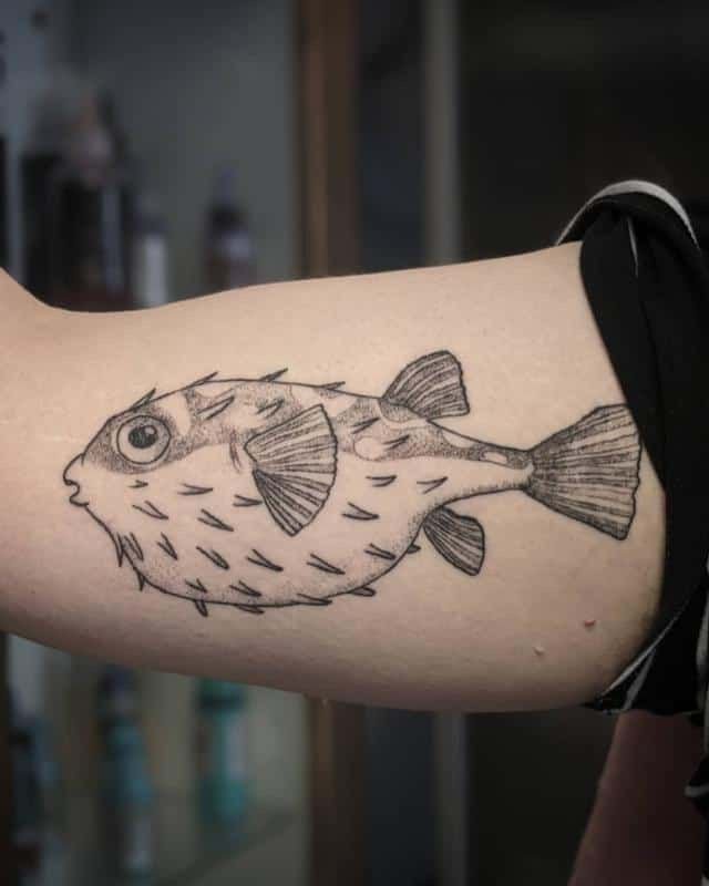 Large fish tattoo on the biceps for men