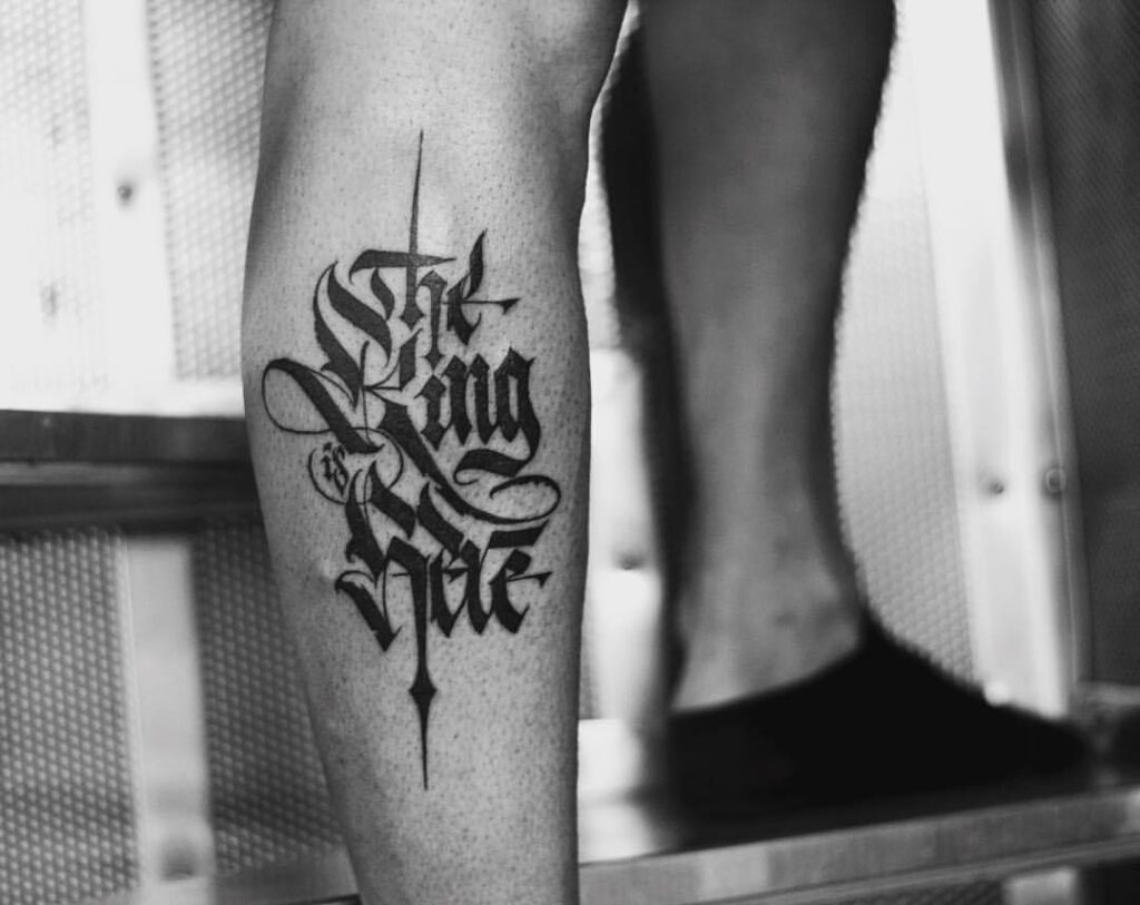 Calligraphy style tattoo on the shin for men