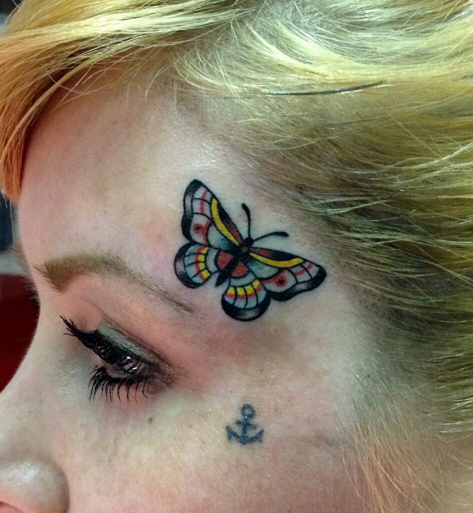 Colored butterfly tattoo on the face for women