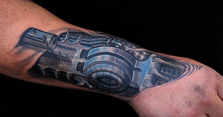 Color biomechanics style tattoo on the forearm for men