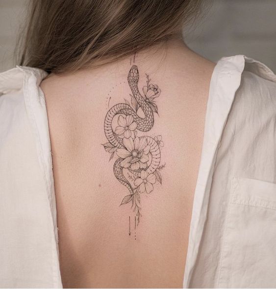 Snake and flowers tattoo on the spine for women