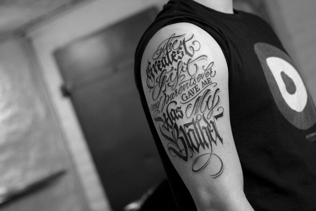 Calligraphy tattoo on the shoulder for men