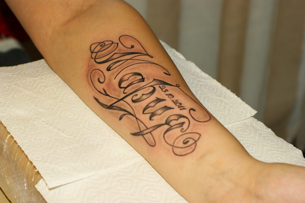 Calligraphy tattoo on forearm for men