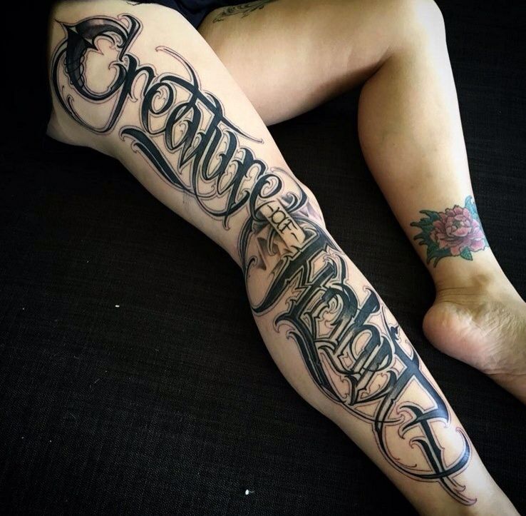 Calligraphy style tattoo on the leg for women