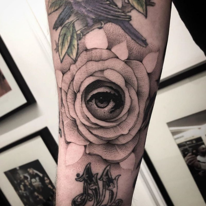 Eye and rose tattoo in graphic style on the forearm for men