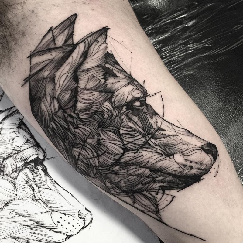 Graphic style wolf tattoo on the biceps for men