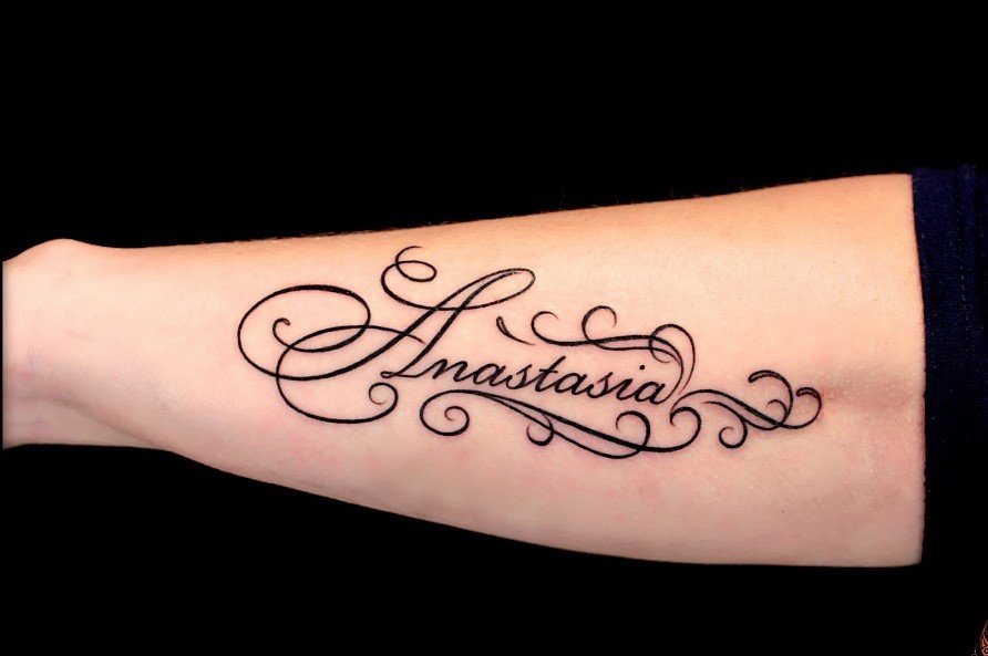 Tattoo with an inscription on the arm for women