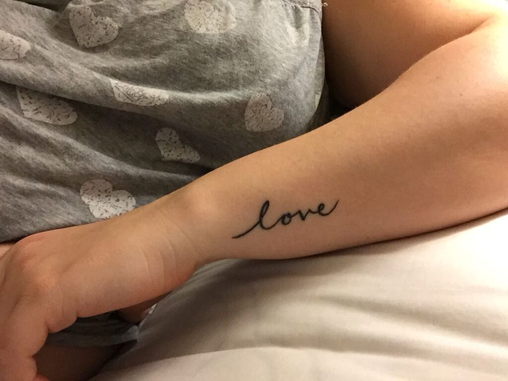 Tattoo with an inscription on the arm for women