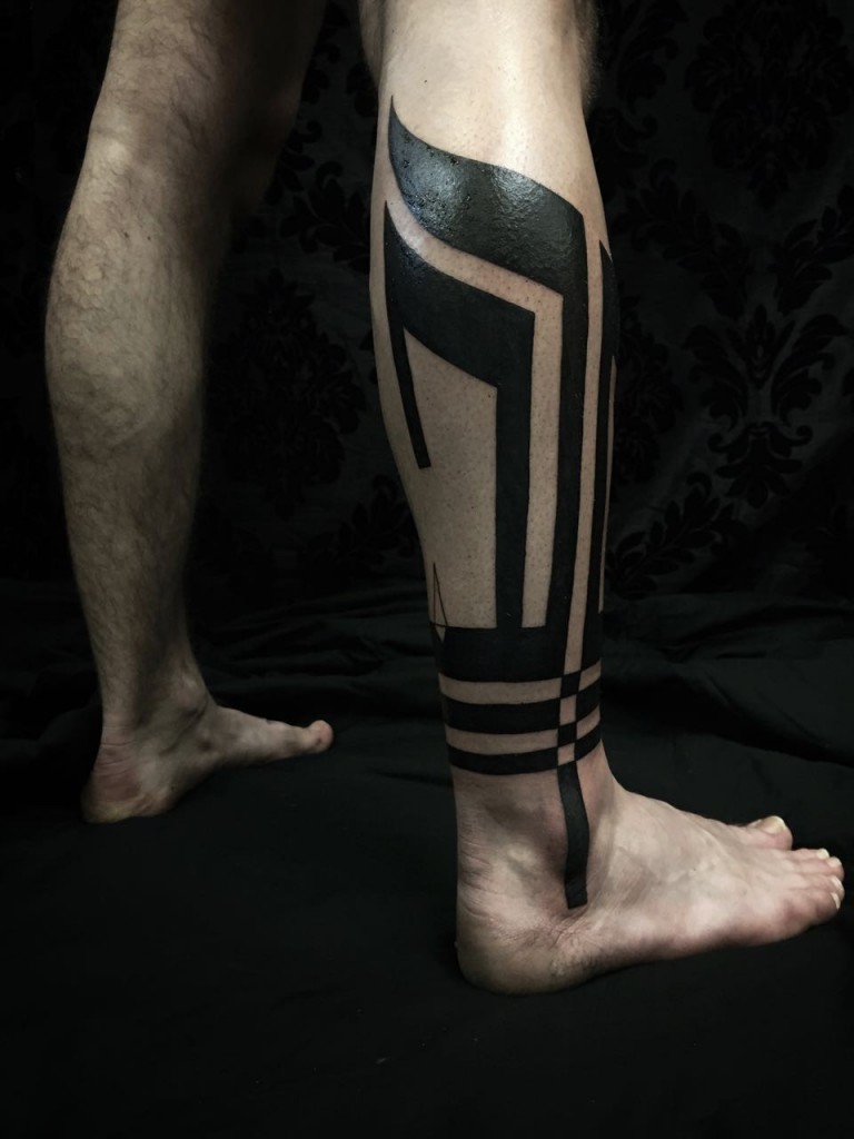 Blackwork style tattoo on the calf for men