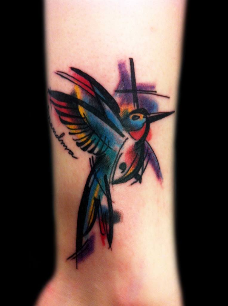 Colorful hummingbird tattoo in art-brut style on the forearm for men