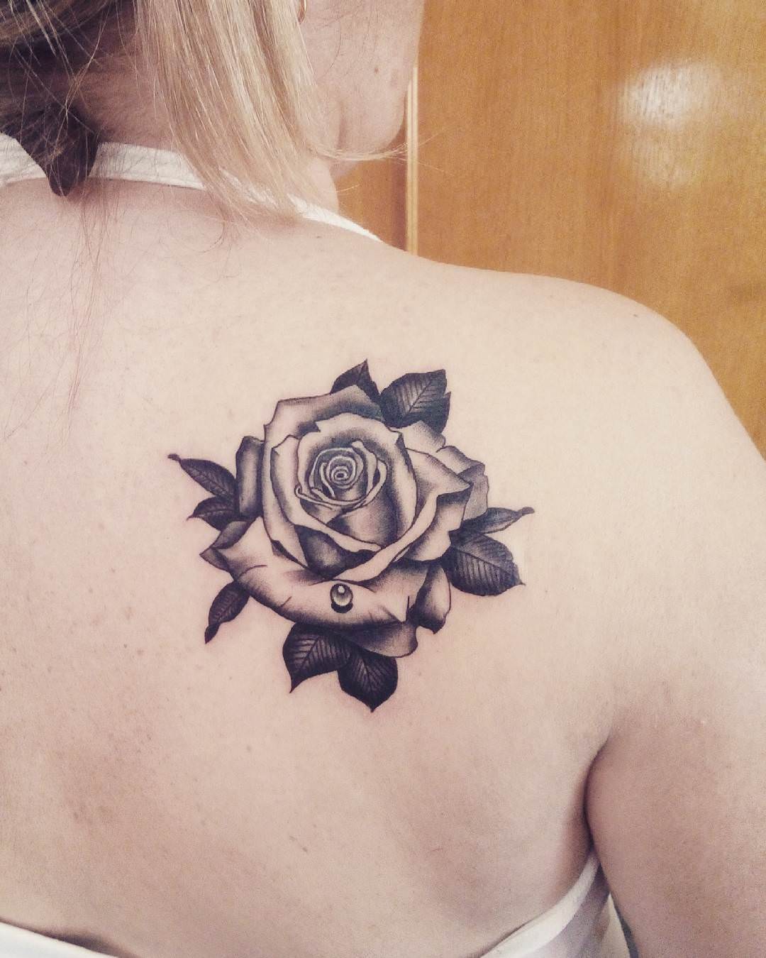 Rose tattoo on the shoulder blade for women