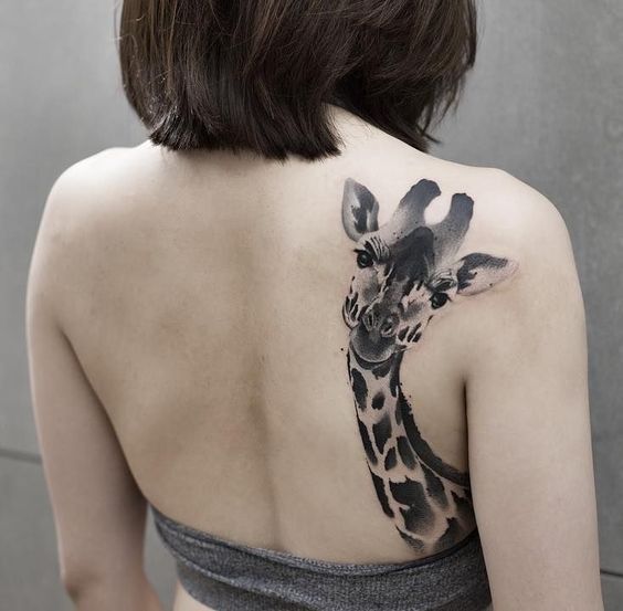 Large giraffe tattoo on the shoulder blade for women