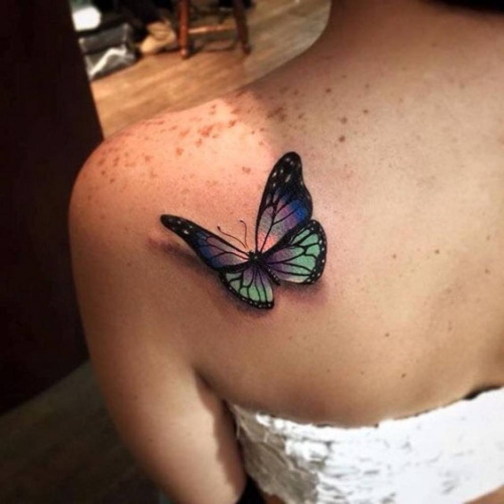 Colored butterfly tattoo on the shoulder blade for women