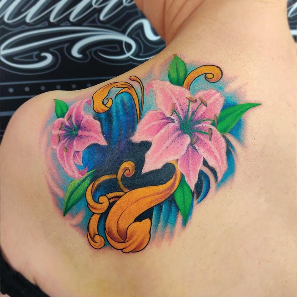 Color lily tattoo on the shoulder blade for women