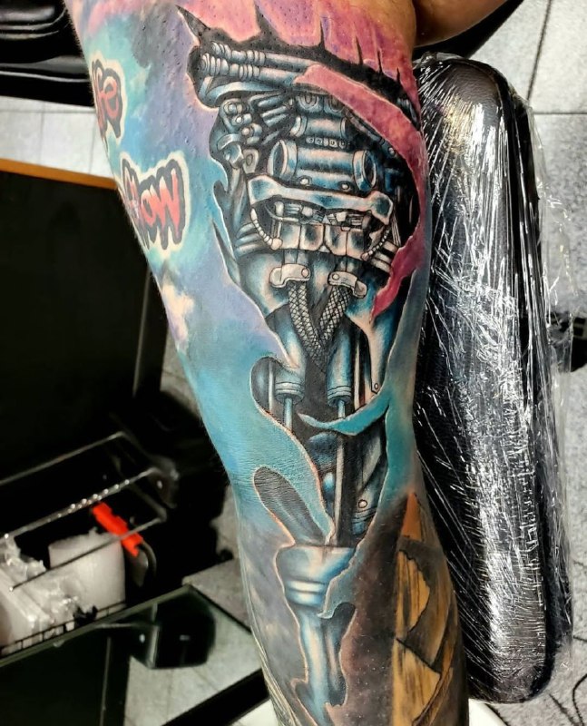 Colored tattoo in the style of biomechanics on the arm for men