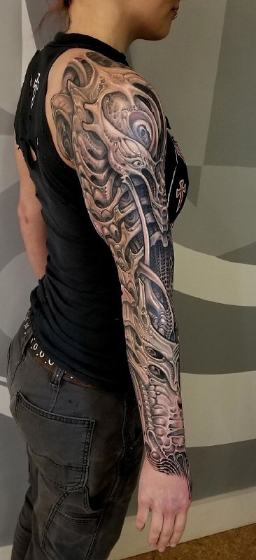 Biomechanics style tattoo on the arm for women