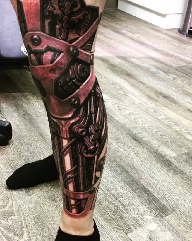 Colored tattoo in the style of biomechanics on the leg for men