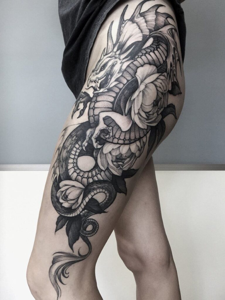 Large dragon tattoo on the thigh for women