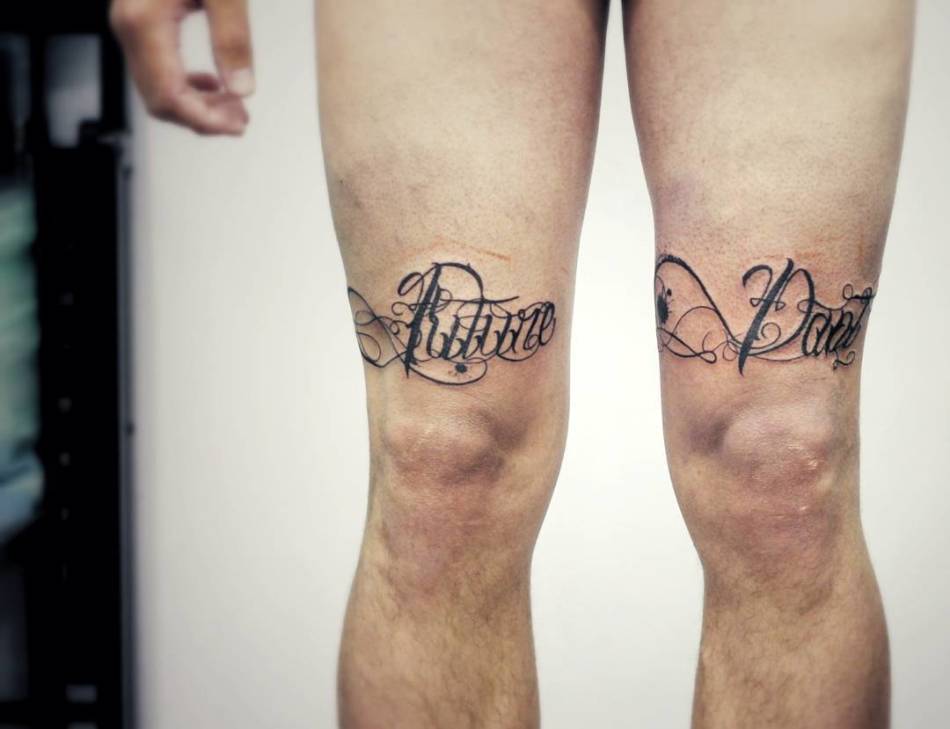 Tattoo with an inscription on the hip for men