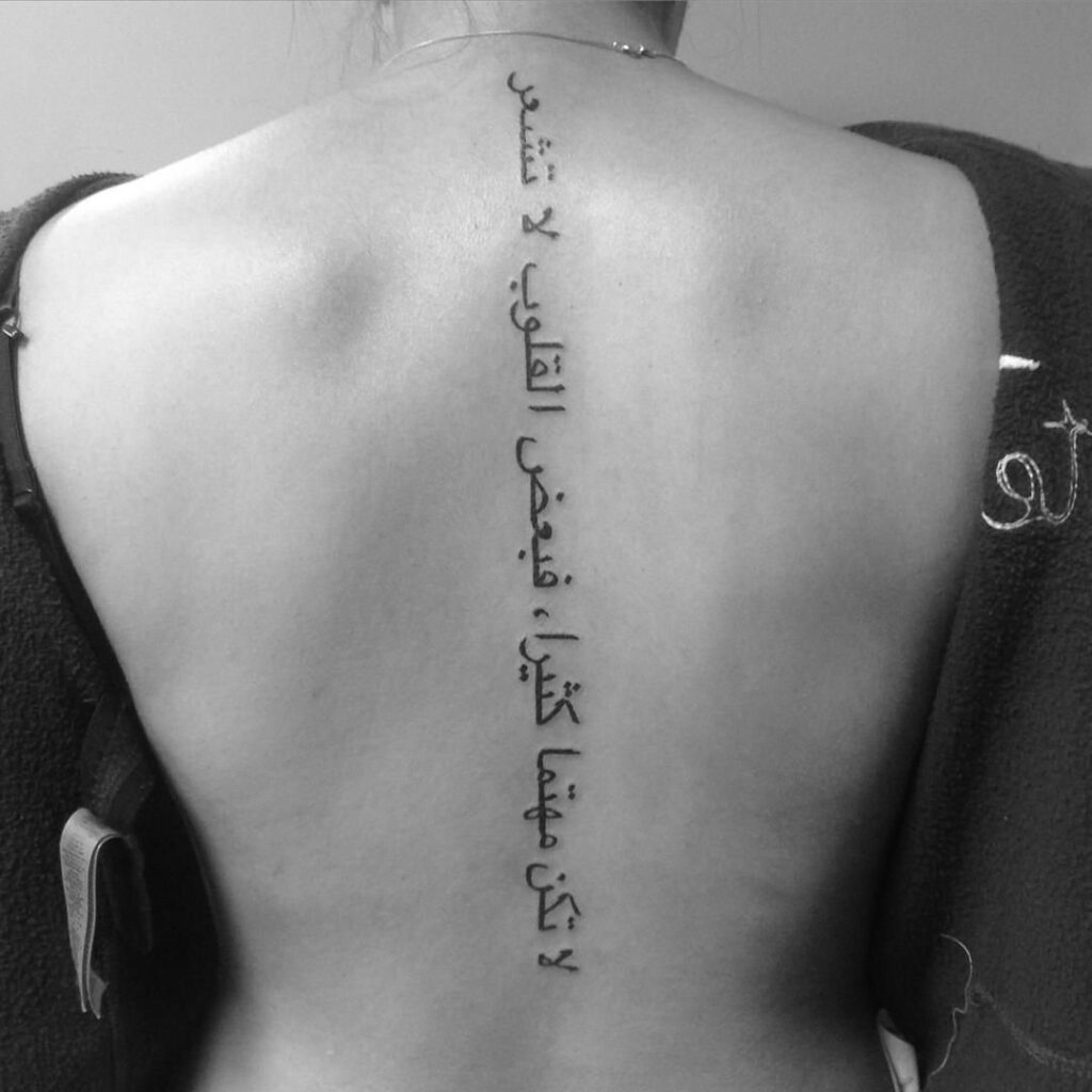 Tattoo with inscription on the spine for women