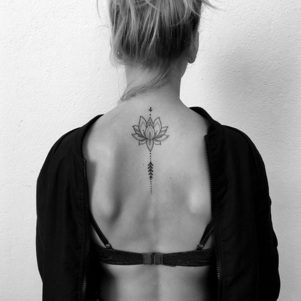 Lotus tattoo on the spine for women