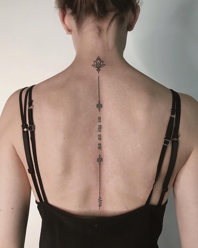 Tattoo with inscription on the spine for women