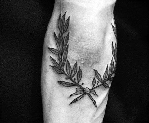 Tattoo of two twigs on the knee for men