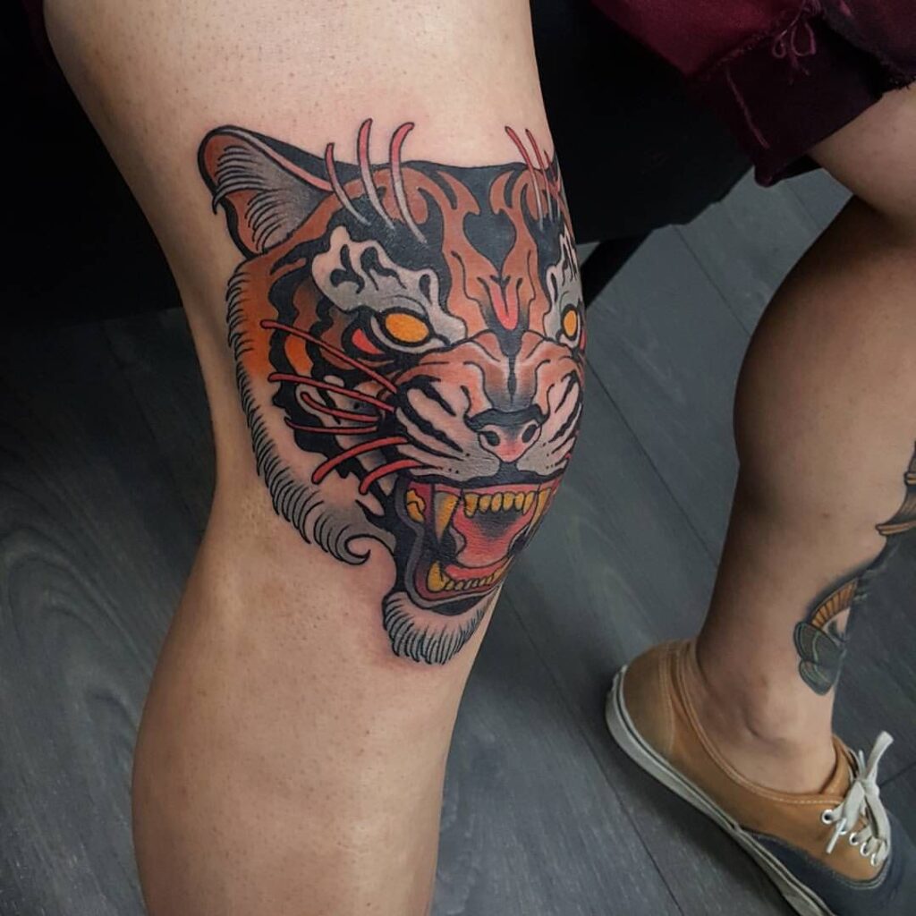 Color tattoo of a tiger on the knee for men