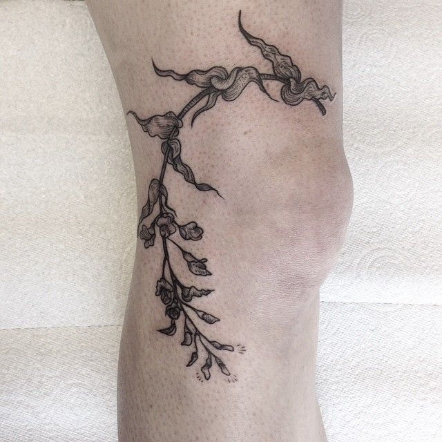 Tattoo of a twig on the knee for men