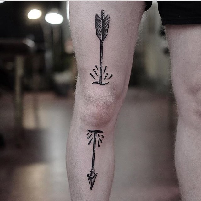 Large arrow tattoo on the knee for men