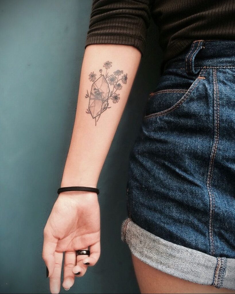 Flower tattoo on the forearm for women