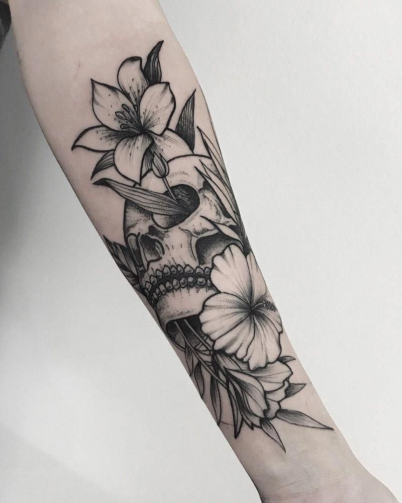 Skull tattoo with flowers on the forearm for women