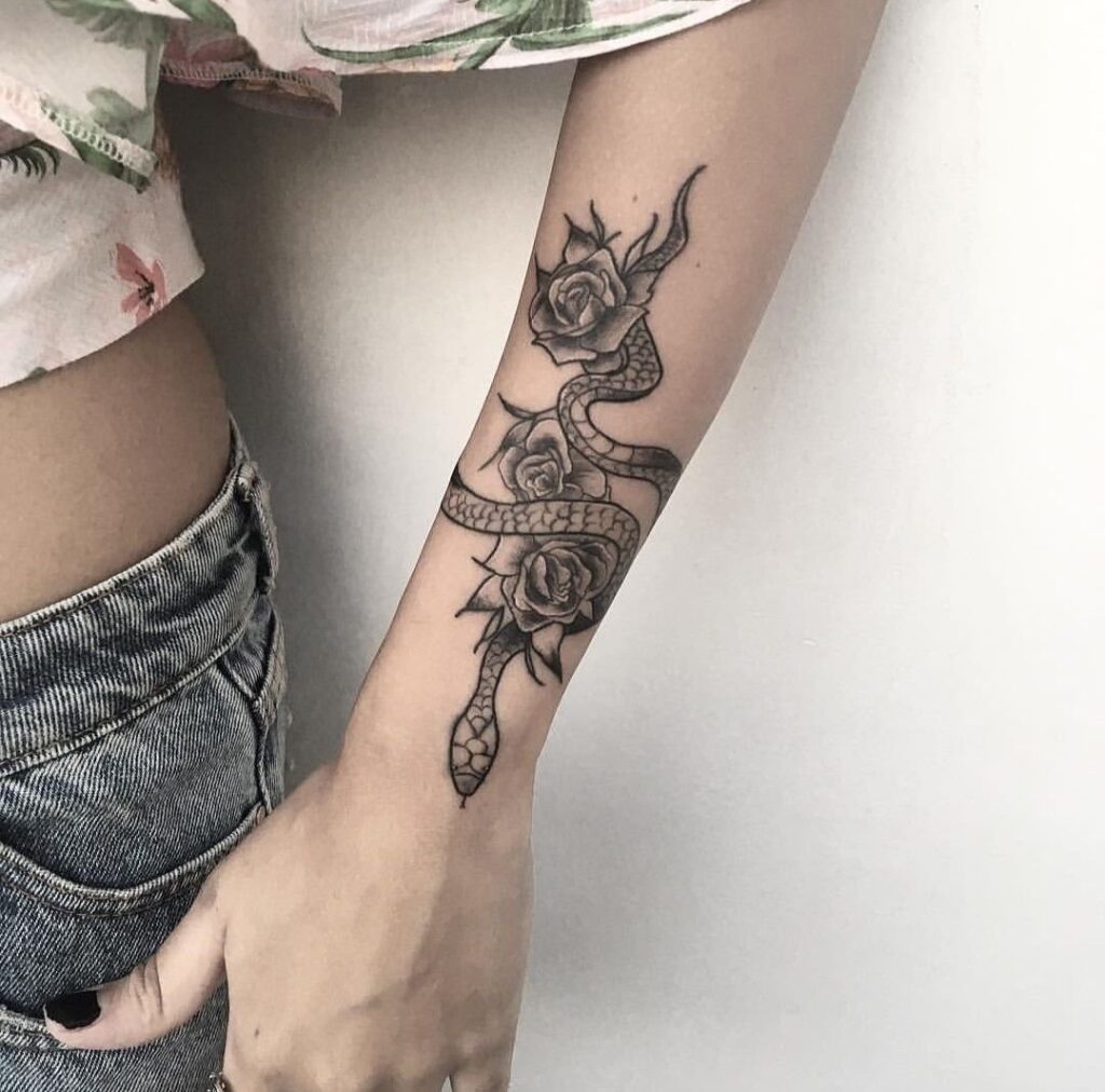 Rose and snake tattoo on the forearm for women