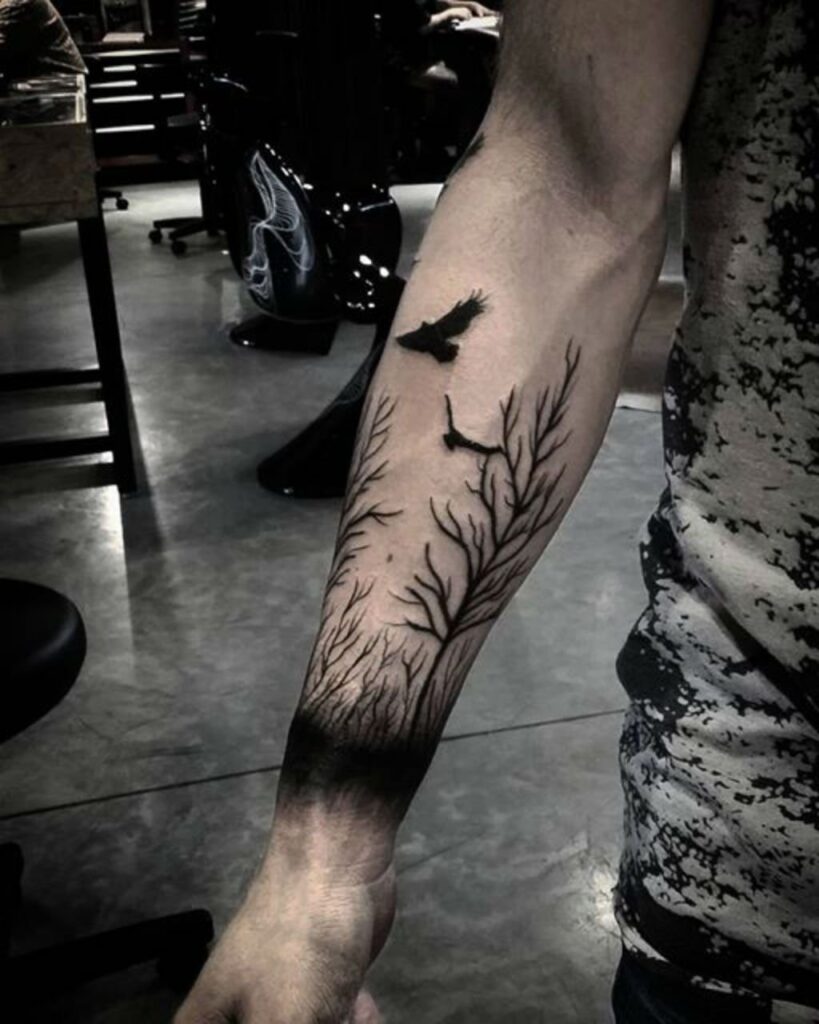 Tree and raven tattoo on the forearm for men