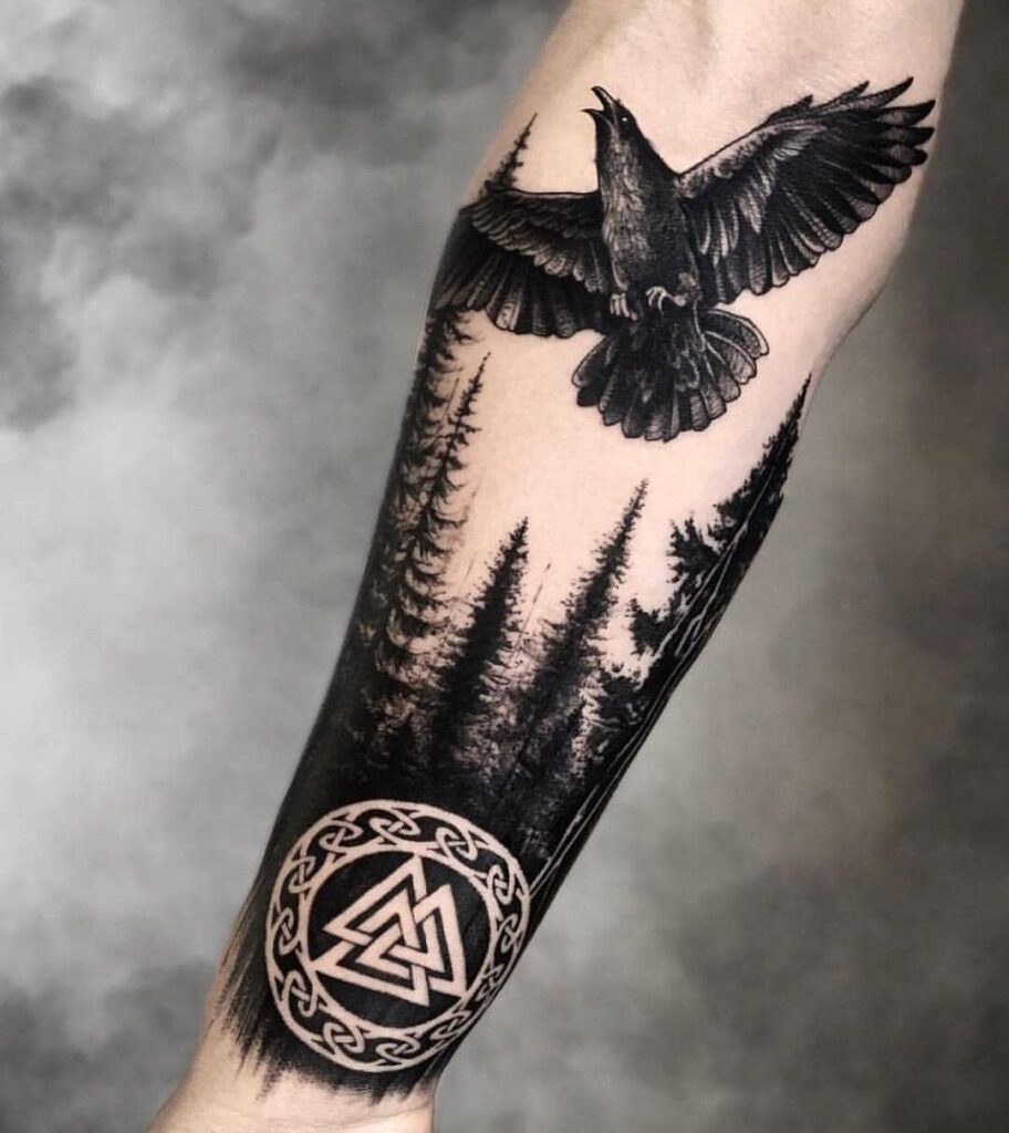 Large forest and raven tattoo on the forearm for men