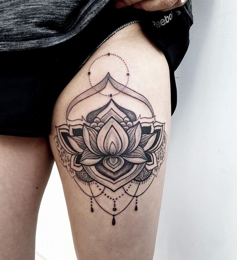 A lotus dotwork tattoo on the thigh for women