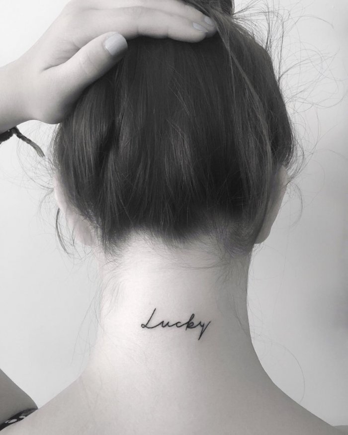 Tattoo with an inscription on the neck for women