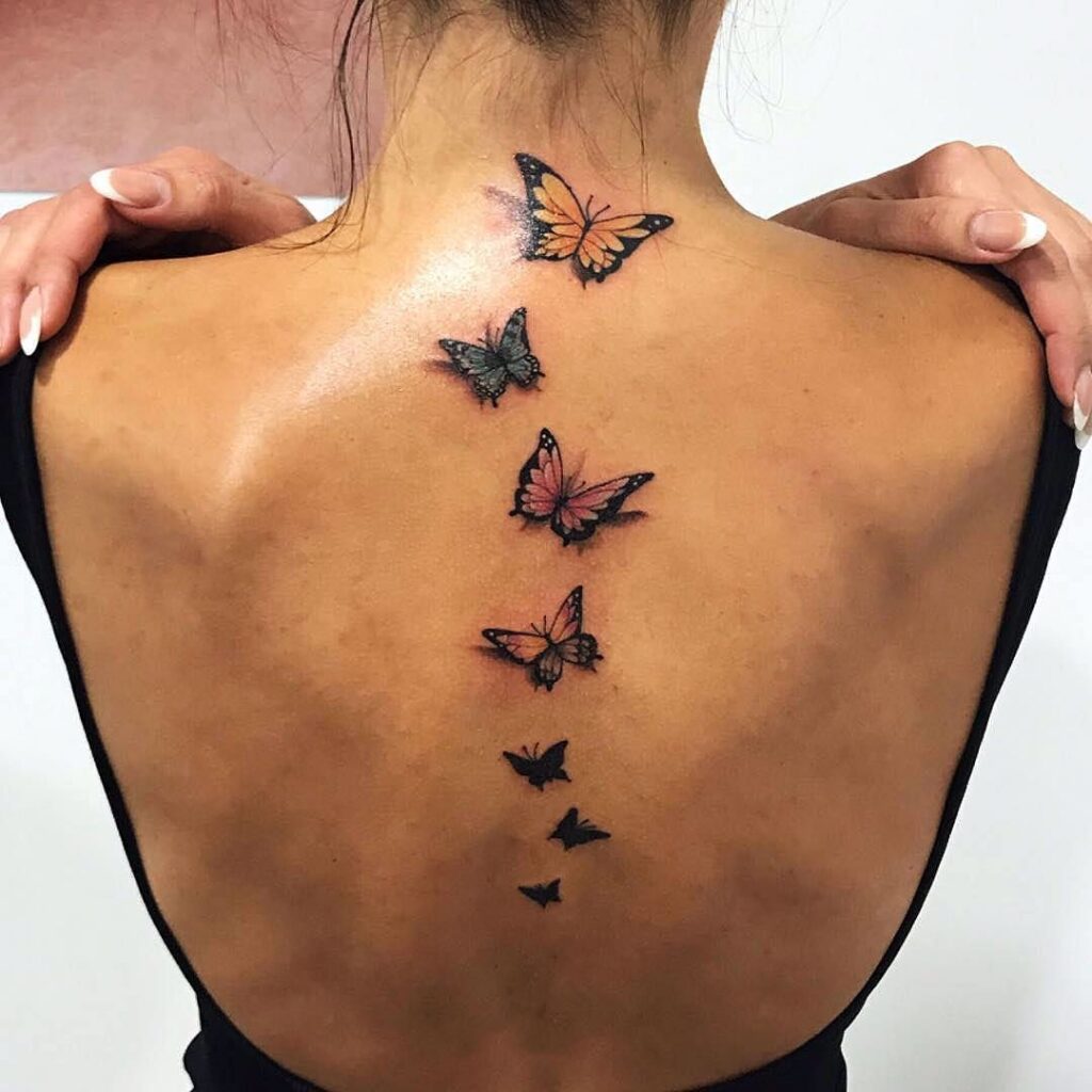 Colored butterfly tattoo on the back for women