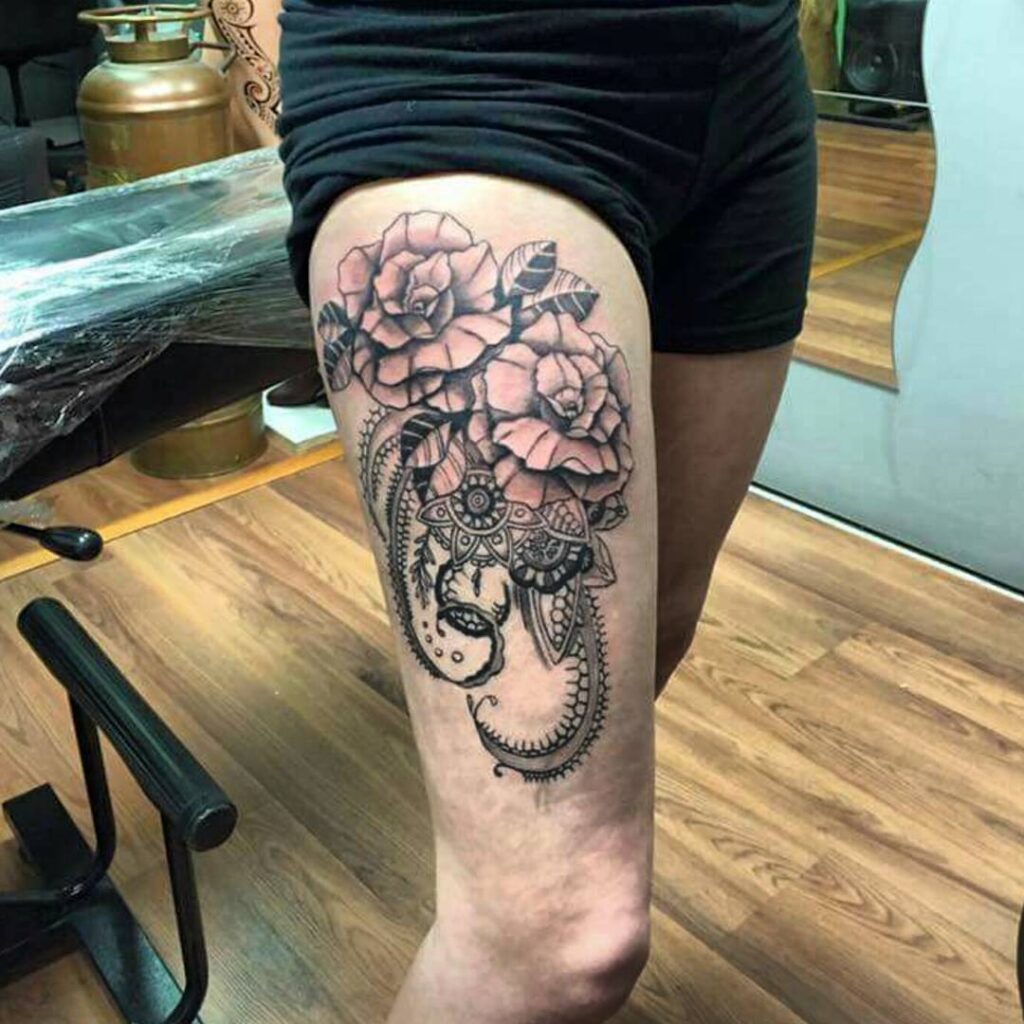 Large baroque tattoo on the thigh for women