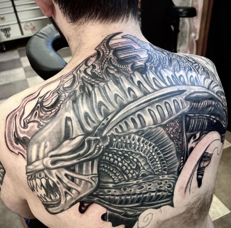 Large biomechanics style tattoo on the back for men