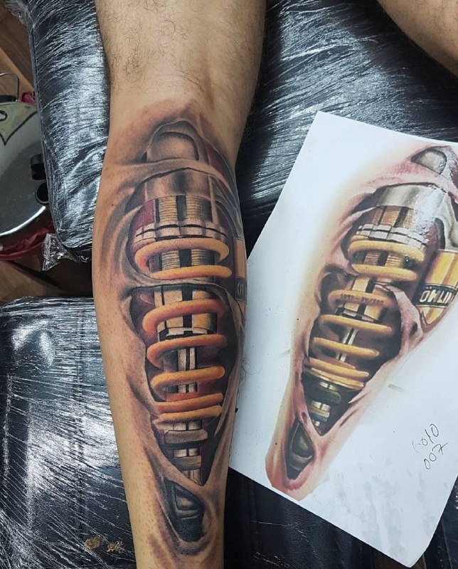 Color biomechanics style tattoo on the calf for men