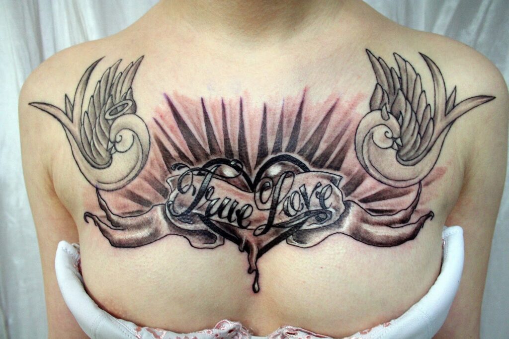 Tattoo with an inscription on the chest for women