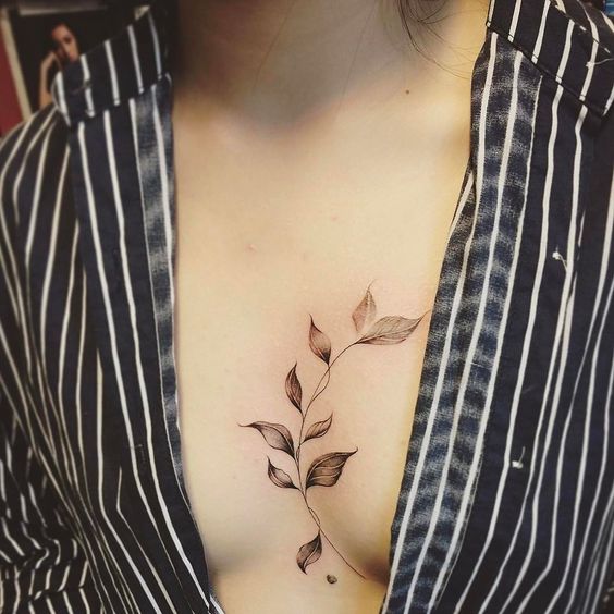 Tattoo of a sprig of leaves on the chest for women