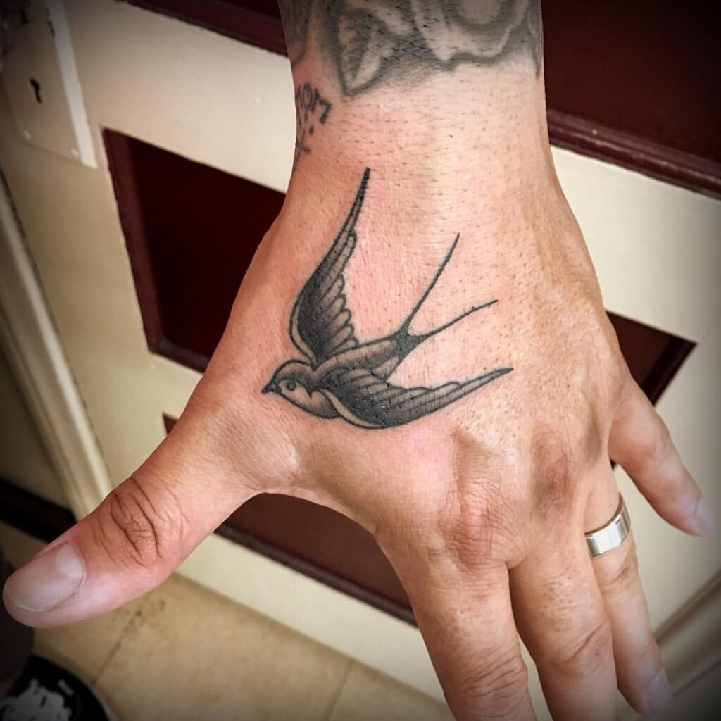 Tattoo of a swallow on the hand for men