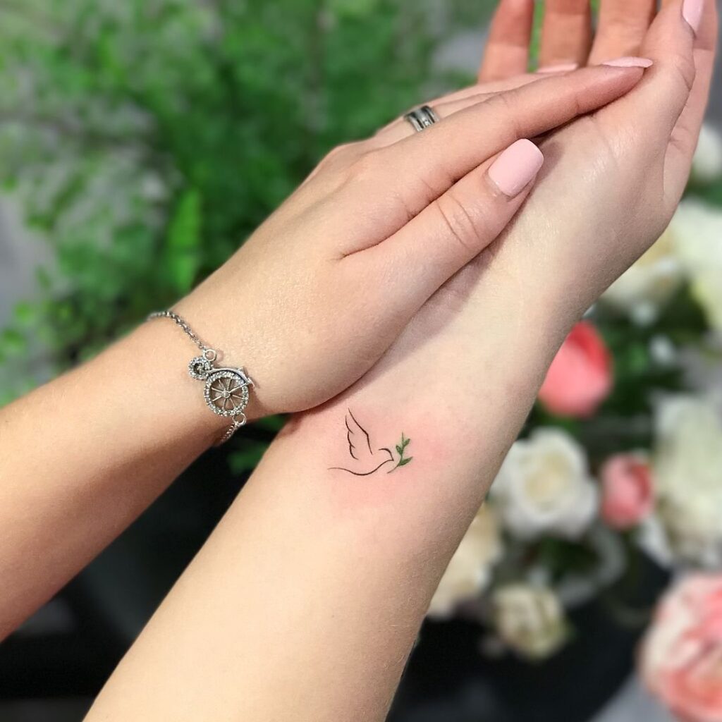 Small tattoo of a dove on the wrist for women