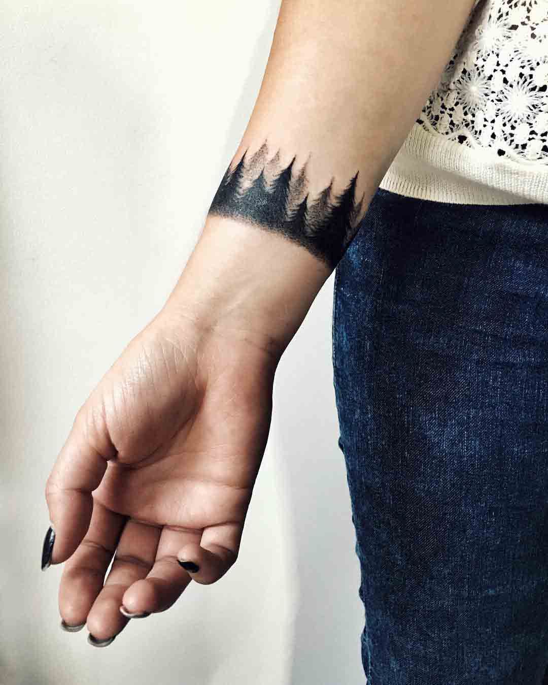 Tattoo of a forest on the wrist for women