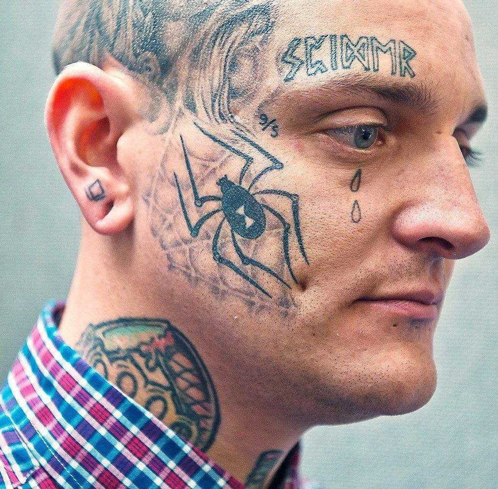 A spider tattoo on the face for men