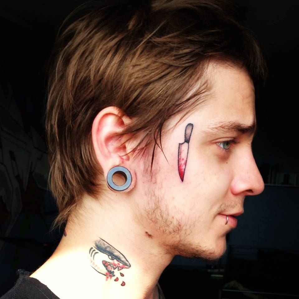 Colorful knife tattoo on the face for men